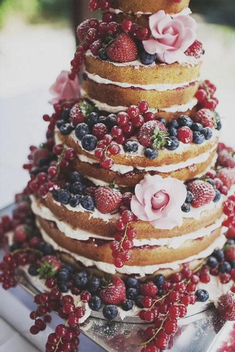 голый свадебный торт украшенный цветами и ягодами